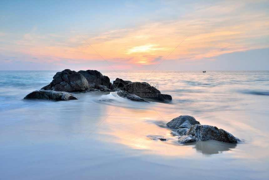 阳光黄昏美丽日落时沙滩的海浪图片