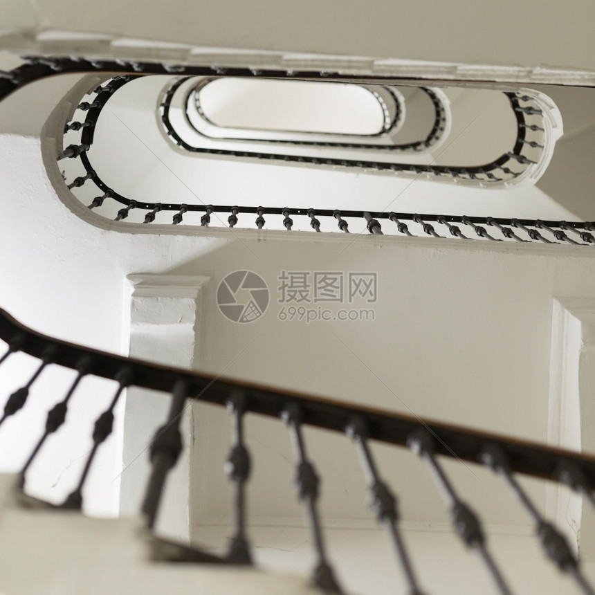 地面多层大楼的白色奥瓦尔下一座多层建筑Stair井多层建筑之下一座多层建筑井抽象的楼梯图片
