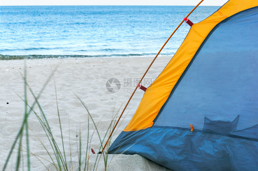 蓝色的支撑晴天沙滩上的黄色帐篷沙滩上的黄色帐篷图片