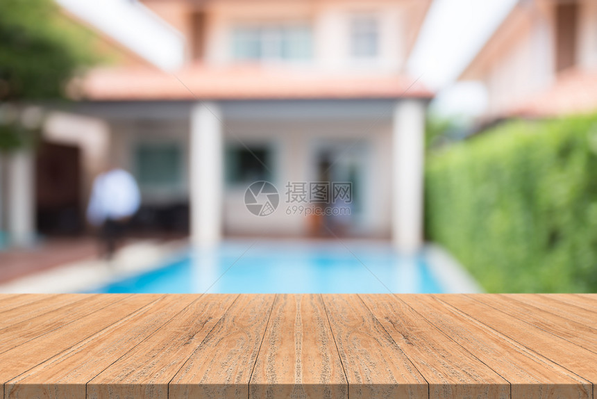 花园游泳池内模糊背景的空木板桌顶上采取游泳的木头图片