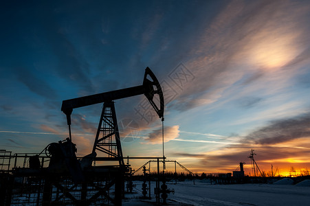 日落时空背景的油泵喷口出石油开采概念原井架西伯利亚图片