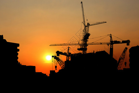 日落时的Silhouette起重机建筑大楼工业起重机建造日出采摘塔图片