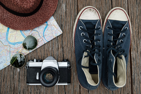 纸游客躺着带有反向相机胶片眼镜和木背底的橡皮物品最顶部视图旅行概念图片