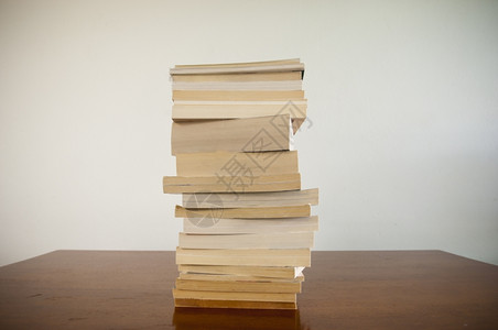 大量书本堆积在一块木材桌面上后空着白教学智力盖子图片