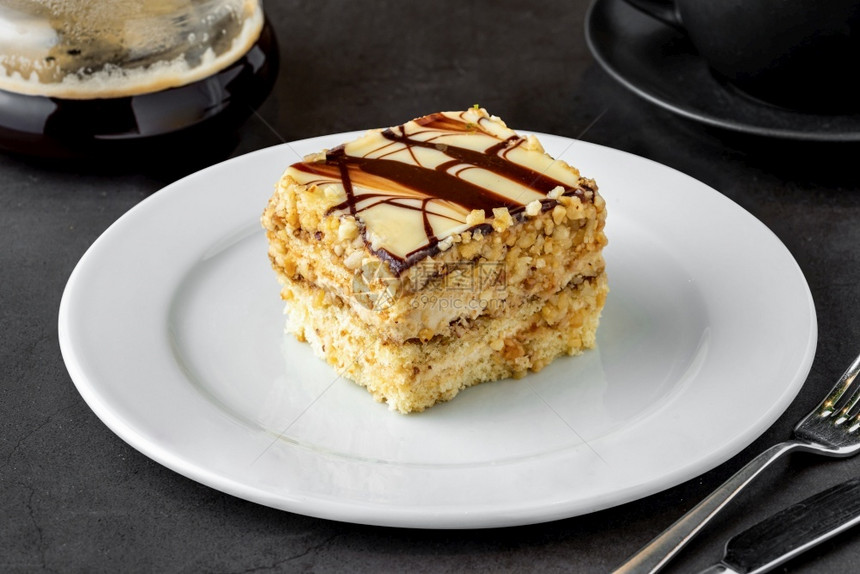 榛子美食饼干黑石头桌上的白巧克力和栗子蛋糕图片