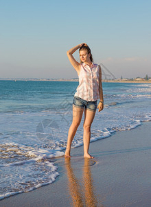 健康阳光日落在夏夜照耀的沙滩上美丽女孩图片