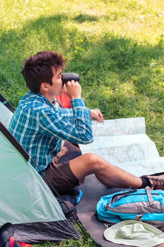 青年男子在露营上度假计划下一趟旅行和喝咖啡的程软垫徒步行者野营图片