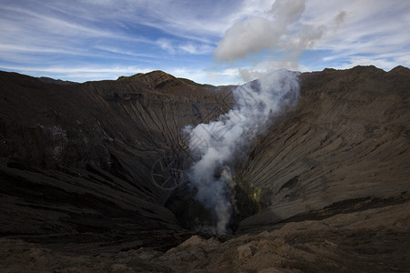 旅行家蒸汽在弹坑内埋有烟雾和硫磺的火山岩浆Bromo图片