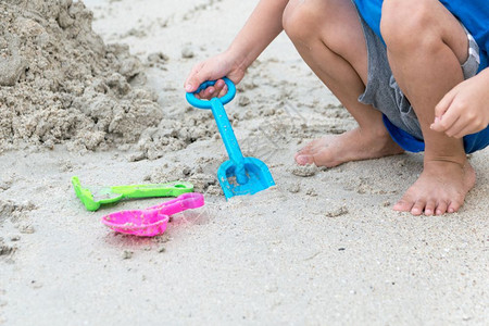 支撑自然男孩在海滩沙上玩耍请享用图片