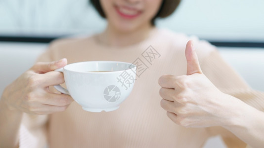 黑色的手好咖啡喝茶或早上喝白杯热饮酒的女子美丽图片