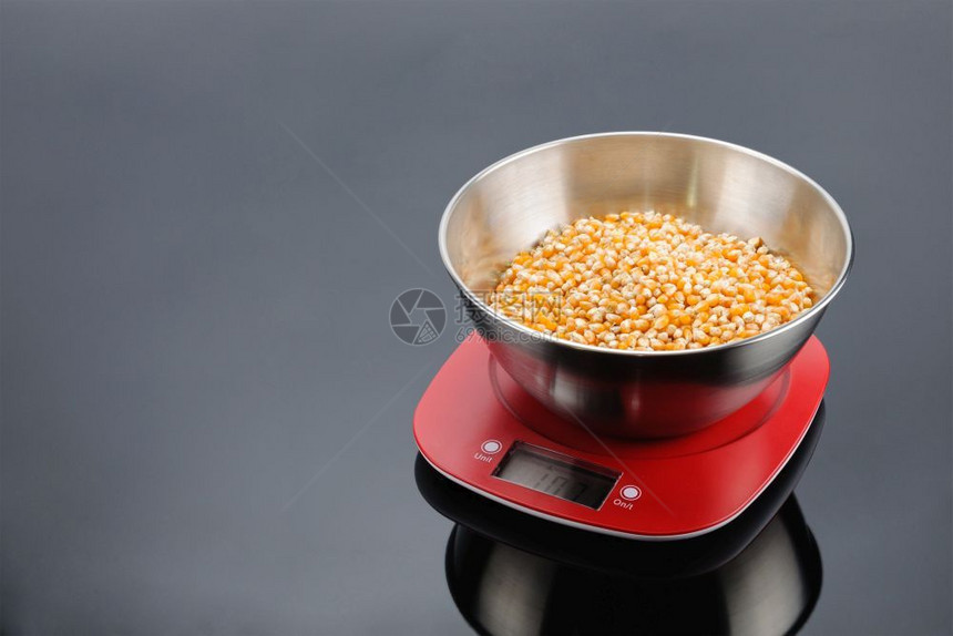 红色的灰镜面背景上红塑料电子秤上不锈钢碗中的玉米复制空间灰色镜面背景上电子秤的碗中玉米带复制空间规模烹饪图片