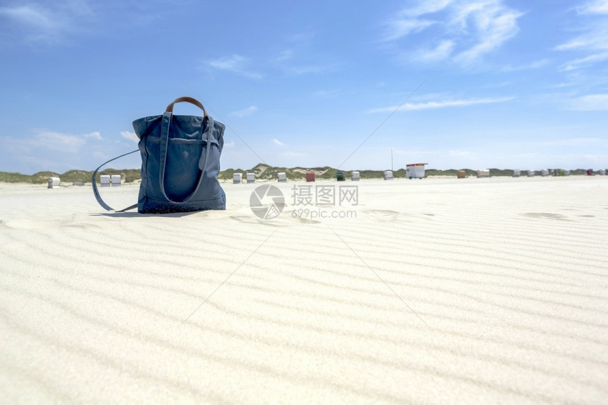 晴天旅游在沙热带海滩上的蓝纺织品沙滩袋低角度近视人们在暑假概念中路过远处行走的风景蓝色图片