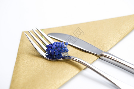花叉和刀子装上蓝色的紫衣草和金餐巾纸干净优雅空白的放用餐图片