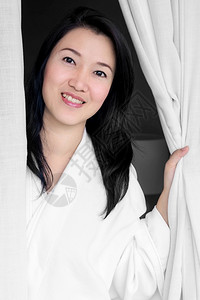 亚洲人布料浴室穿着白袍笑的亚洲妇女打开了房间窗帘穿白袍的妇女微笑了图片