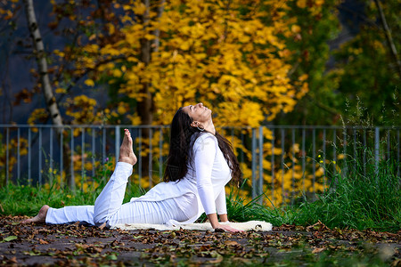 训练放松弛白色女孩在公园的瑜伽姿势高清图片