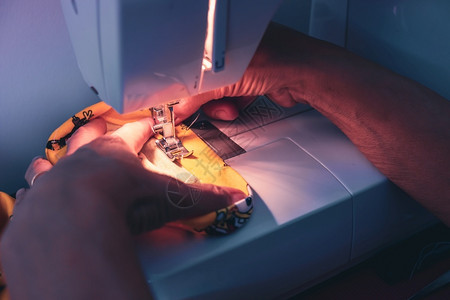 工艺行业女用缝纫机在冠状白贫血期间用缝纫机面罩工作图片