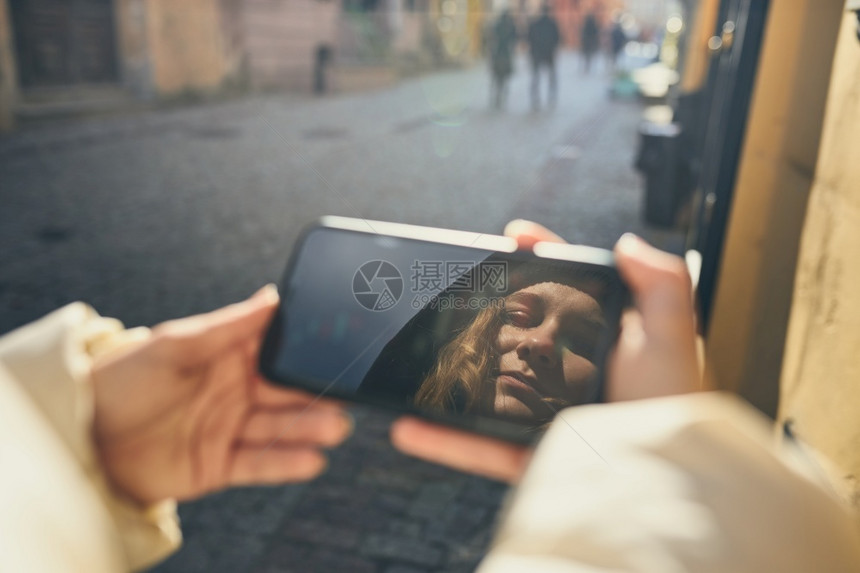 有视频电话的年轻女子通过远程交谈拍摄自相照片手持智能机在屏幕上出现面孔社会的自拍保持图片