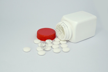 阿司匹林剂量生活白种下孤立的药瓶和丸背景图片