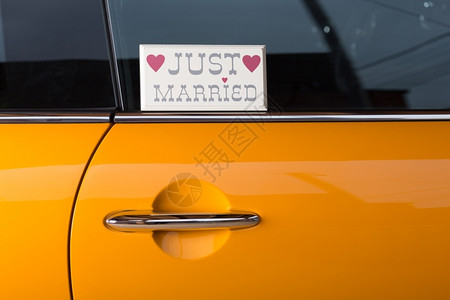 幸福已婚车辆新夫妇在他的橙色汽车里旅行度蜜月设计图片