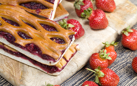 带草莓和红果酱的自制蛋糕切成零碎的自制蛋糕美丽食卷发图片