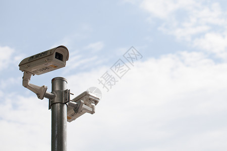 监控立杆闭路电视摄像头对着线杆在白天的晴后面隐私控制外部的背景
