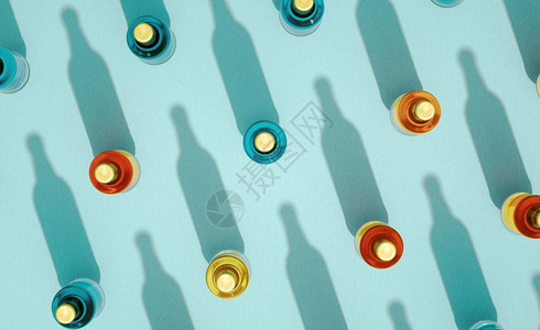 蓝色的喝装有金属盖的几瓶玻璃最顶部视景这些玻璃瓶站在绿宝石蓝底的色背景上啤酒瓶各种颜色有长影子Retro饮料瓶概念绿松石背景图片