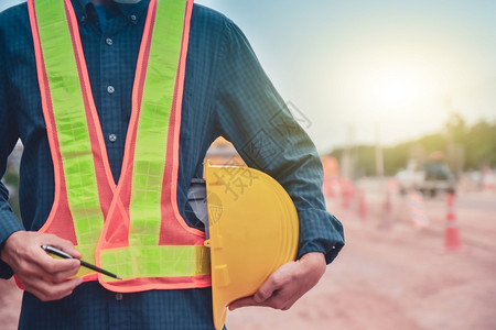 紧贴身戴硬帽的工程师站在道路建筑背景上站立服务安全保护图片