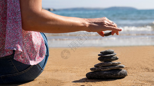岩石人们近距离接在和平海滩度假时填满女石块鹅卵图片