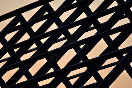 屋面天空日落时建造的钢铁屋顶框架建筑木板外部的图片