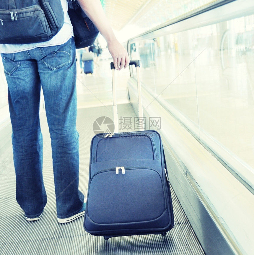 行李旅者在高速走上携带一个手提箱假期推车图片