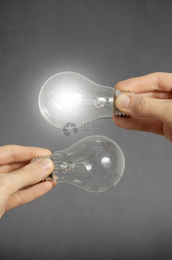 手持两个灯泡其中一在发光手持两个灯泡其中之一正在发光创造力行业舍纳塔根图片