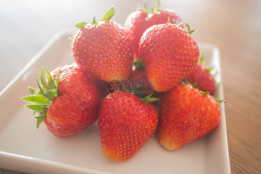 生活白色盘子上新鲜成熟的草莓股票照片新鲜的叶子图片