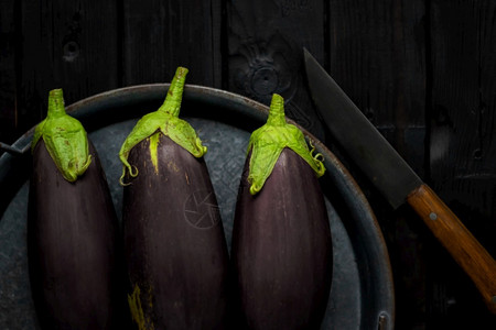 素食主义者有机的木菜板上带刀茄子木制菜板上带刀的紫色茄子健康图片