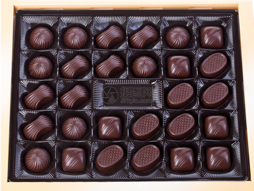 黑暗的在白色背景上被隔离的巧克力盒式密闭糖果仁小吃图片