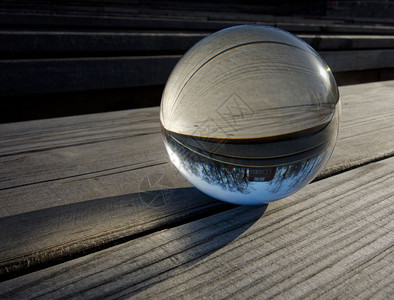 圆形的球水晶背景和纹理木制桌上的玻璃球折射内风景的一部分玻璃球折射图片