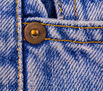 老的材料帆布关闭旧蓝色牛仔裤上的按钮图片
