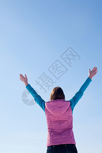 崇拜少女与举起的手站在蓝天对面克拉夫琴科女士图片