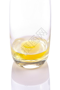 黄色的营养丰富白在透明玻璃杯上装有黄蛋的新鲜鸡图片