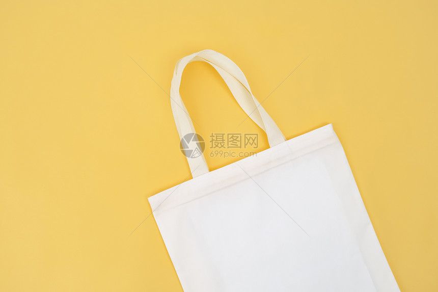 手提包店铺黄色背景下分离的织物袋白色图片