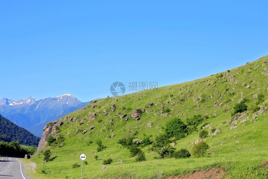 蓝色的高加索山脉之间通向南高加索的公路树阿尔卑斯山图片