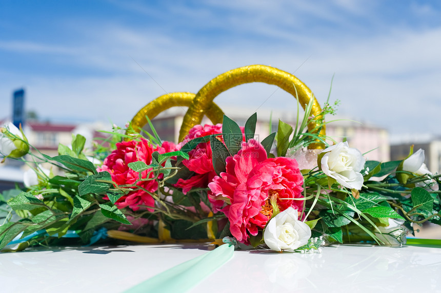 浅的金环和鲜花作为婚礼汽车装饰品自由度天图片