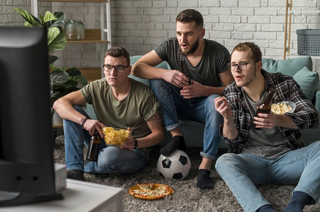坚果人们抽象的三位男朋友一起看体育电视一边喝小点心啤酒图片