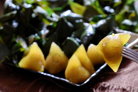 五月日越南传统食物双五节或Tetdoanngo绿叶上粘糊的米糕也称为金字塔形状的banhuTro甜的糕点称呼背景图片