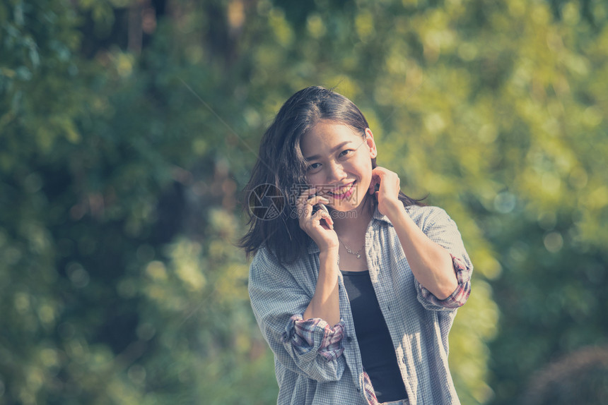 吸引人的们年轻亚洲女在绿色公园用手机交谈的笑脸在手机上说着话肖像图片