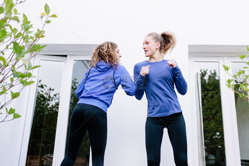 两名年轻妇女在露天台一起锻炼运动鞋教练员绑腿图片