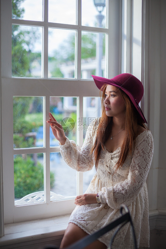 肖像窗外望的萨达西古老女人伤心孩图片