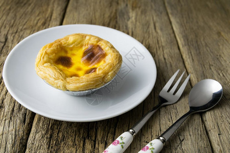 木头背景上美味的葡萄牙鸡蛋薄饼圆形的甜点粉彩图片