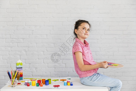 丰富多彩的高考虑坐在白桌肖像画女孩混合水彩色调盘图片