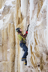 冒险攀登运动的年轻人用冰斧在上爬图片