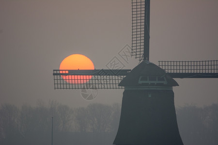 薄雾文化农场日出寒冬清晨与风车图片